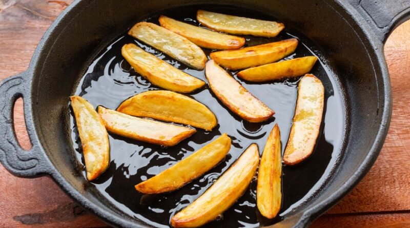 Freshly fried golden potato wedges sizzling in a cast iron skillet, showcasing delicious homemade cooking. - Photo by Laura oliveira on Pexels
