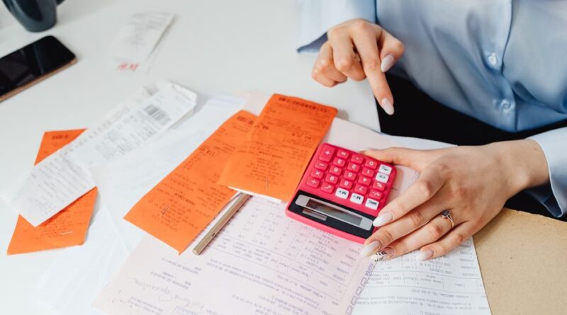 Businesswoman calculates expenses using receipts and calculator at desk. Ideal for finance, accounting themes. - Photo by https://kaboompics.com/ on Pexels